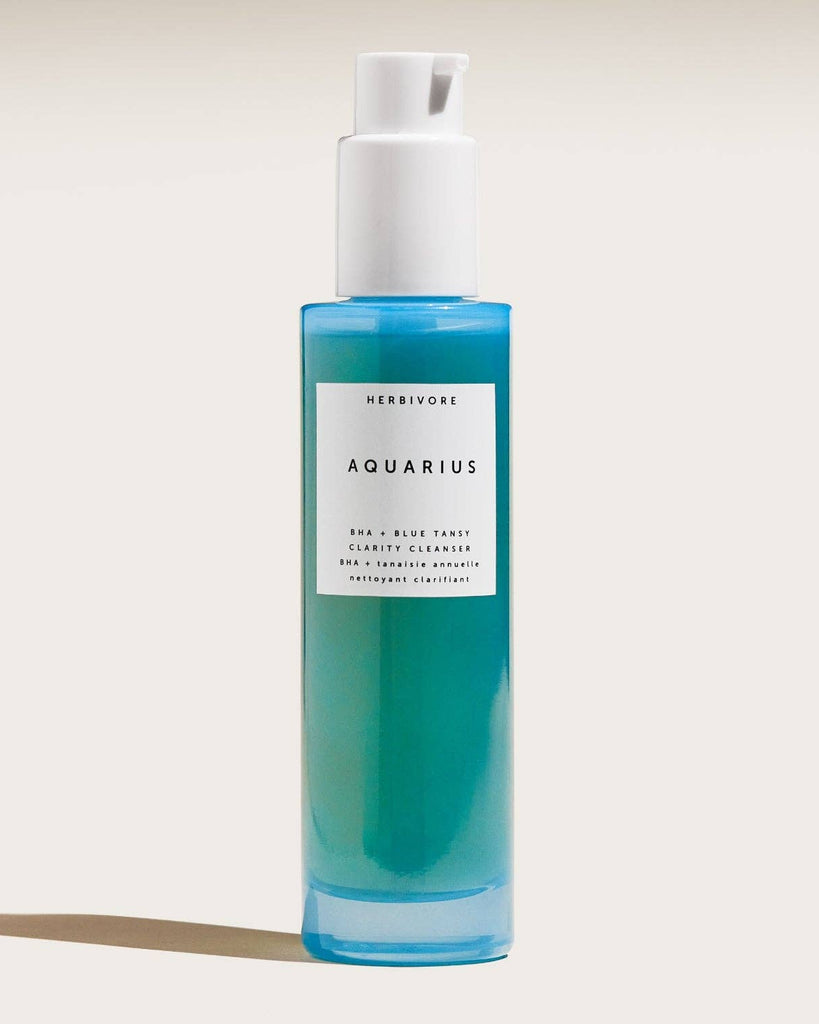 Blue bottle with white cap labeled 'Aquarius' on a light beige background